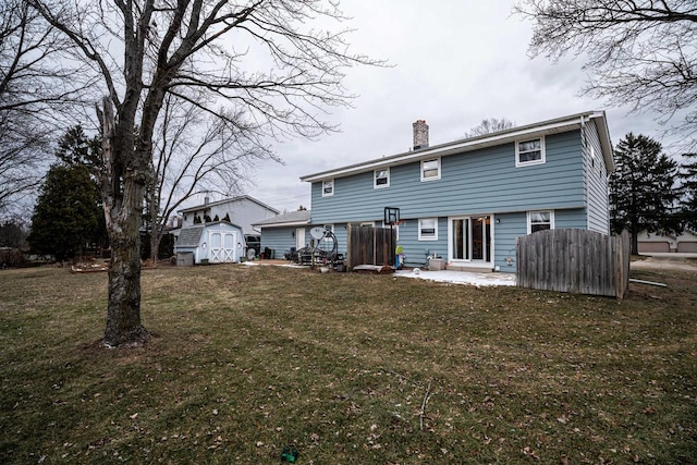 back of property featuring a patio area, a lawn, and a storage shed