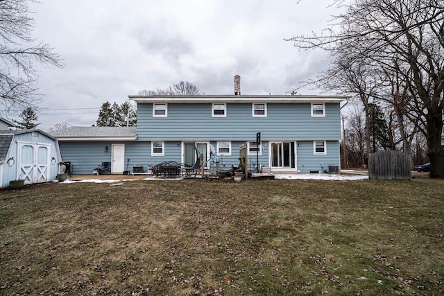 rear view of property with a yard, a storage shed, a patio, an outdoor fire pit, and cooling unit