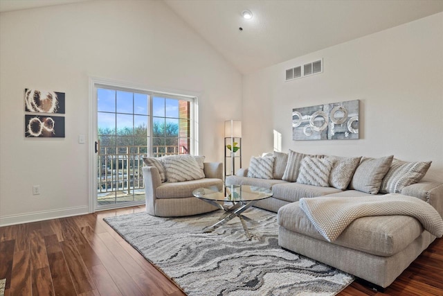 living room featuring high vaulted ceiling and dark hardwood / wood-style floors