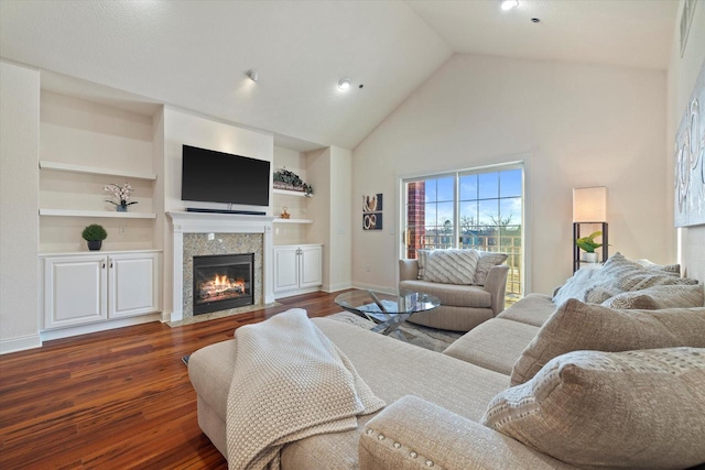 living room with built in shelves, vaulted ceiling, and dark wood-type flooring