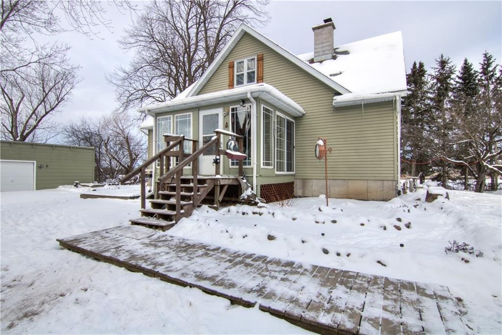 view of snow covered back of property