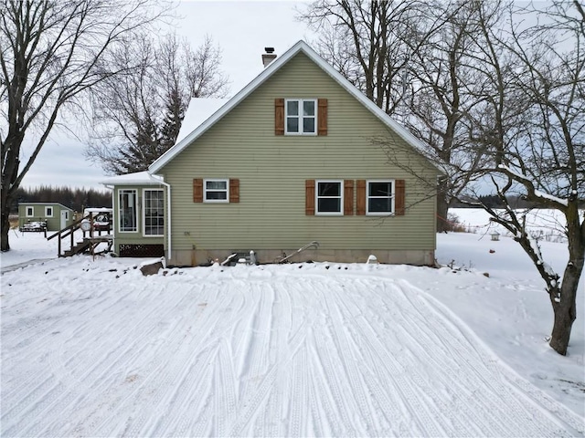 view of snow covered back of property