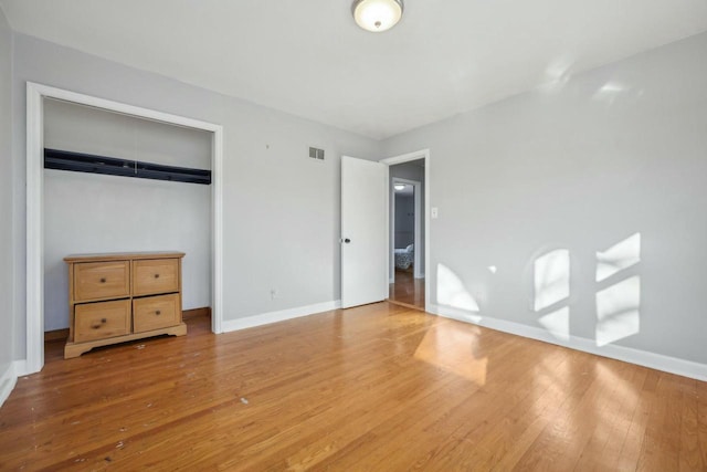 unfurnished bedroom featuring light wood-type flooring and a closet