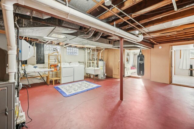 basement featuring water heater, independent washer and dryer, and electric water heater