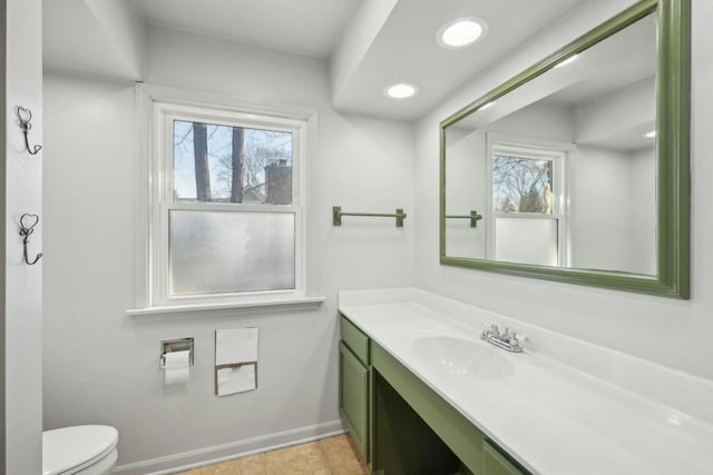 bathroom with plenty of natural light, toilet, vanity, and tile patterned flooring