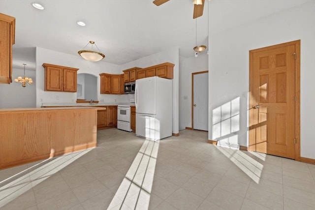 kitchen featuring kitchen peninsula, white appliances, hanging light fixtures, ceiling fan with notable chandelier, and sink