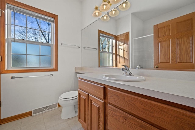 bathroom featuring toilet, vanity, walk in shower, and tile patterned flooring