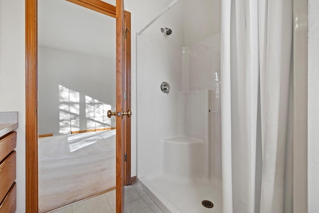 bathroom with walk in shower, tile patterned floors, and vanity