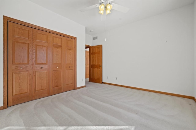 unfurnished bedroom featuring light carpet, ceiling fan, and a closet