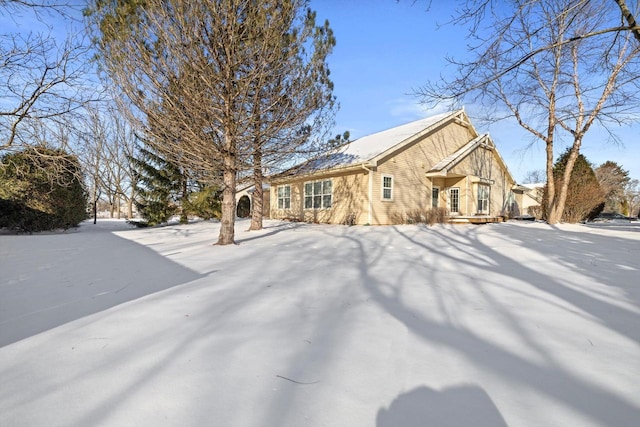 view of snow covered back of property