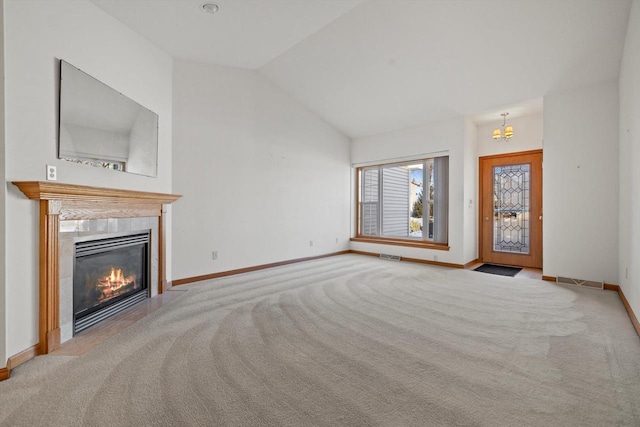 unfurnished living room featuring an inviting chandelier, lofted ceiling, light colored carpet, and a tiled fireplace