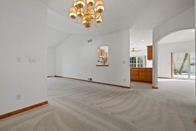 unfurnished living room featuring light carpet, vaulted ceiling, and ceiling fan with notable chandelier