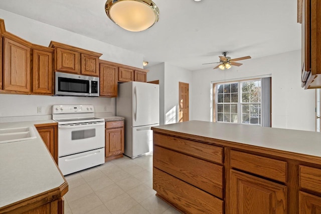 kitchen featuring ceiling fan, sink, and white appliances