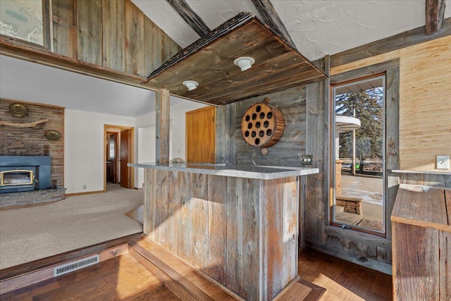 N4621 Lake Dr, Hustisford, WI 53034 - bar with carpet flooring, a wood stove, and wooden walls