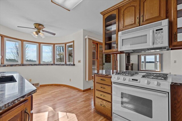 N4621 Lake Dr, Hustisford, WI 53034 - kitchen featuring ceiling fan, light hardwood / wood-style flooring, dark stone counters, and white appliances