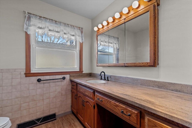 N4621 Lake Dr, Hustisford, WI 53034 - bathroom with toilet, vanity, tile walls, and wood-type flooring