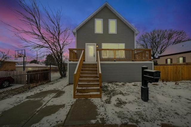 back house at dusk featuring a deck