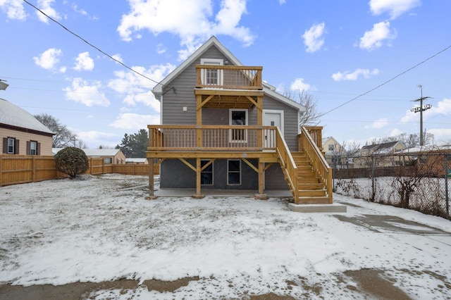 snow covered property with a deck