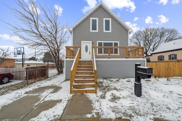 snow covered house featuring a deck