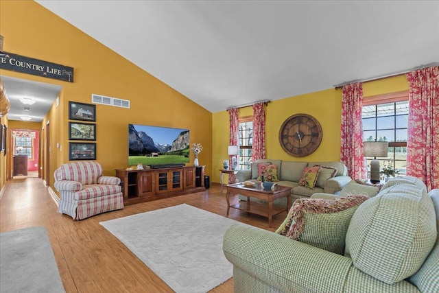 living room with vaulted ceiling and light hardwood / wood-style floors