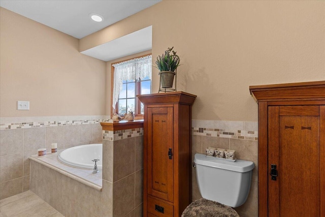 bathroom with tiled bath, tile walls, toilet, and tile patterned flooring