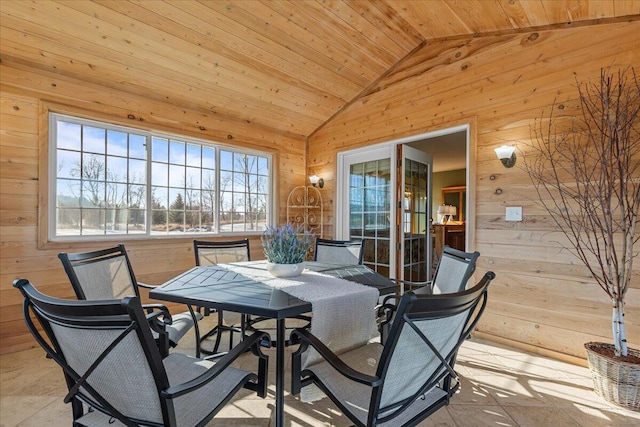 dining room featuring vaulted ceiling, wooden ceiling, and wood walls