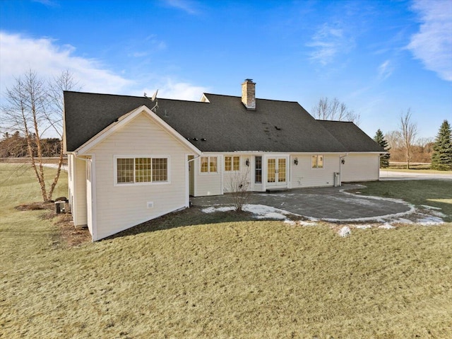 back of property with a lawn, french doors, and a patio