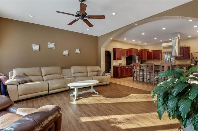 living room with ceiling fan and light hardwood / wood-style flooring