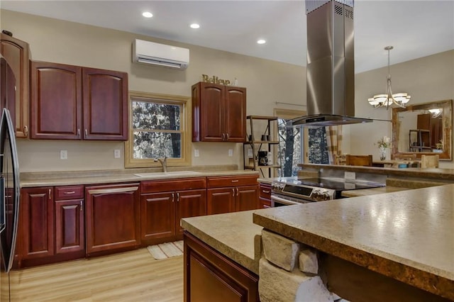 kitchen with a wall unit AC, an inviting chandelier, hanging light fixtures, dishwashing machine, and island range hood