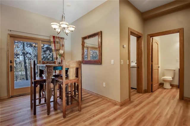 dining area with an inviting chandelier and light hardwood / wood-style flooring