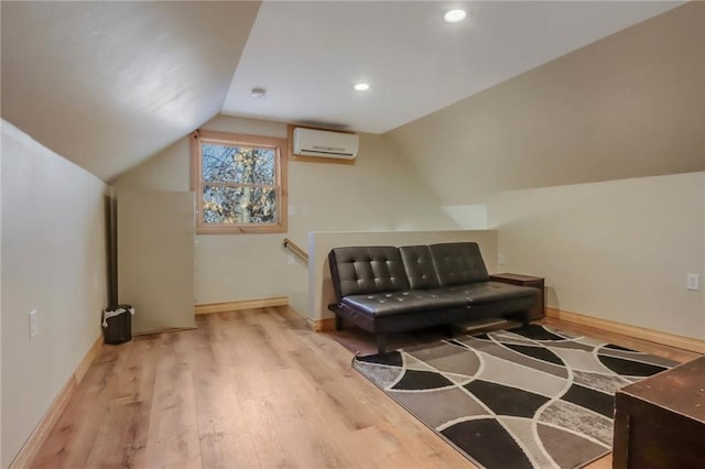 sitting room featuring an AC wall unit, vaulted ceiling, and light hardwood / wood-style floors