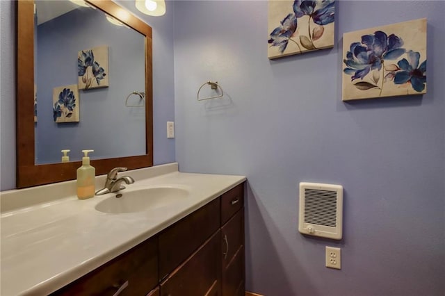 bathroom featuring heating unit and vanity