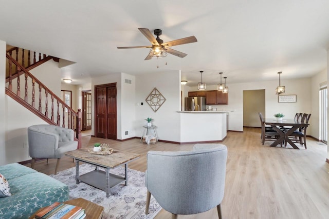 living room featuring ceiling fan and light hardwood / wood-style flooring