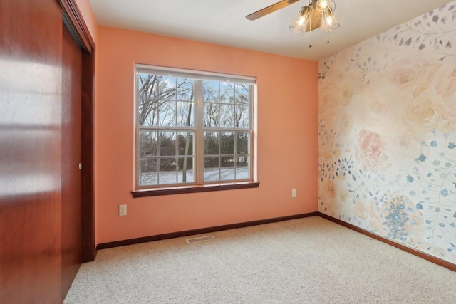 empty room featuring ceiling fan and carpet flooring