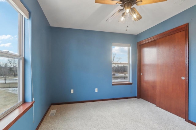 unfurnished bedroom featuring ceiling fan, a closet, and carpet floors