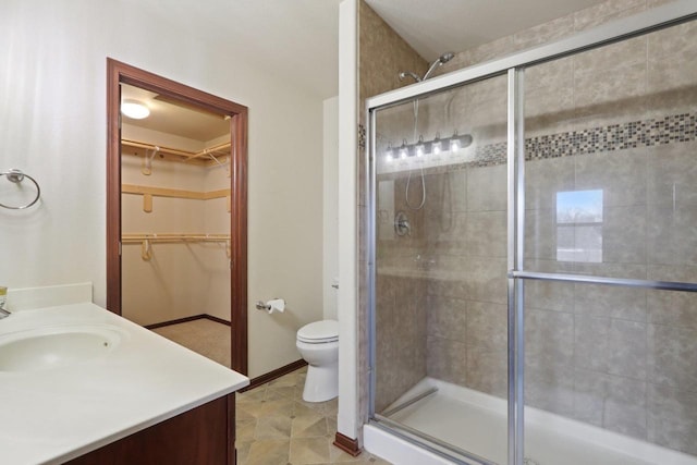 bathroom with vanity, toilet, and a shower with door