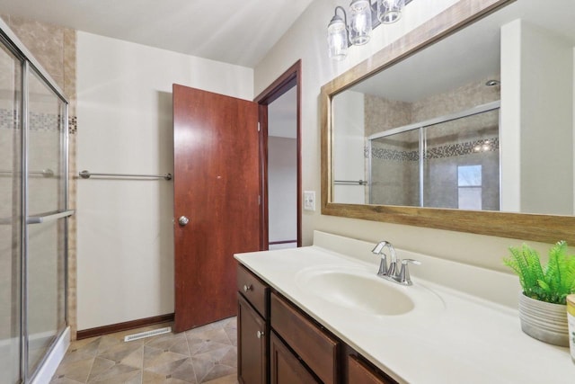 bathroom with a shower with shower door and vanity