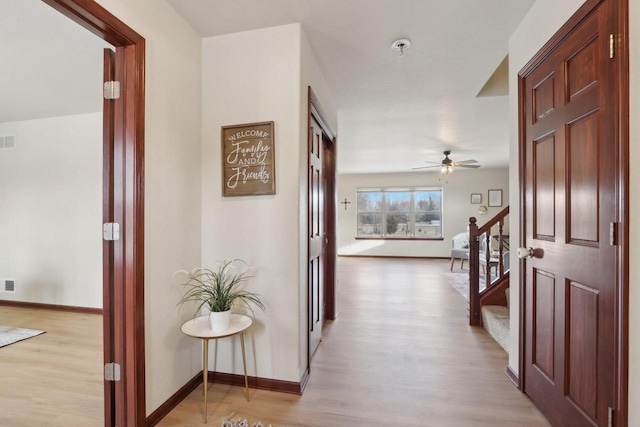 corridor with light hardwood / wood-style floors