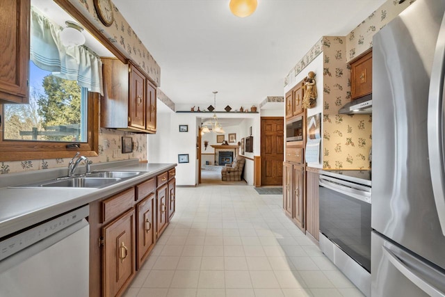 kitchen featuring appliances with stainless steel finishes, sink, and pendant lighting