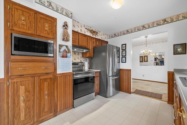 kitchen with stainless steel appliances, hanging light fixtures, and a notable chandelier