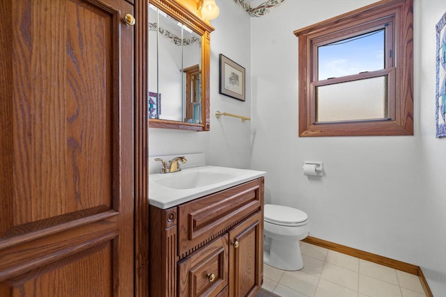 bathroom with toilet, vanity, and tile patterned flooring