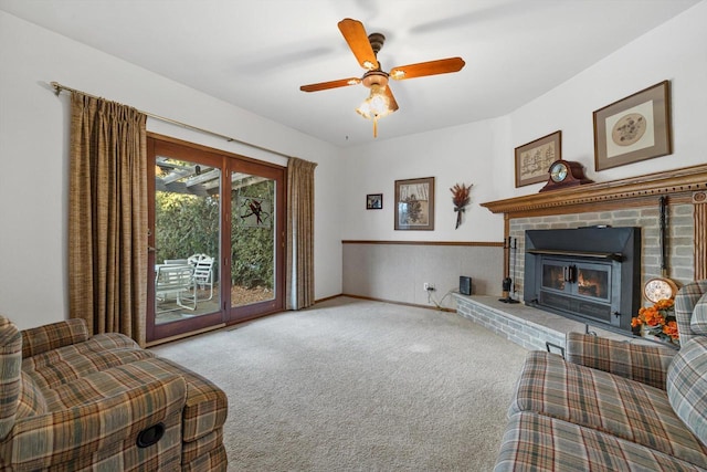 living room featuring a fireplace, ceiling fan, and light colored carpet