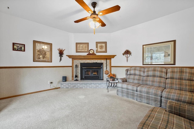 carpeted living room with ceiling fan and a fireplace