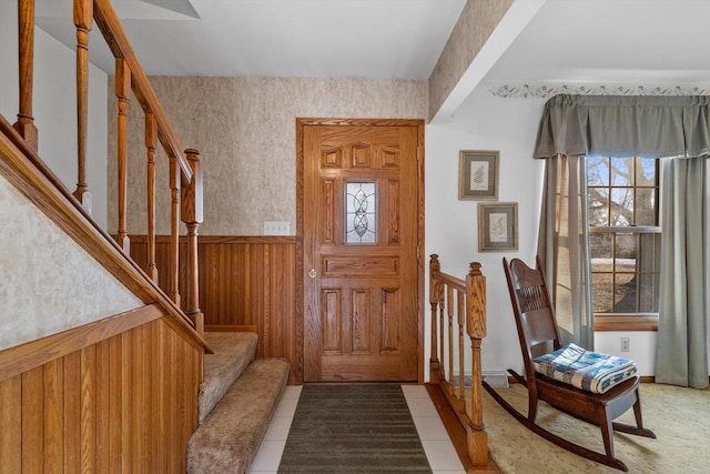 entrance foyer with light tile patterned floors and wooden walls