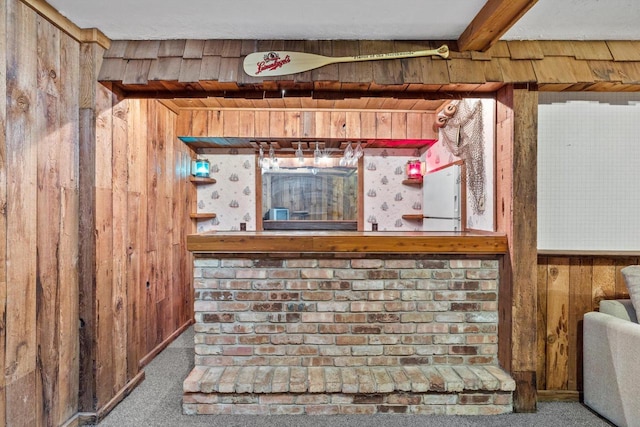 interior details featuring beam ceiling, wood walls, and carpet flooring