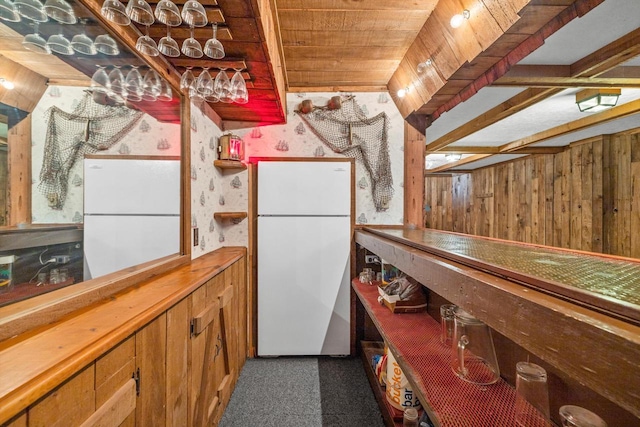 kitchen featuring white refrigerator, wood ceiling, and wooden walls