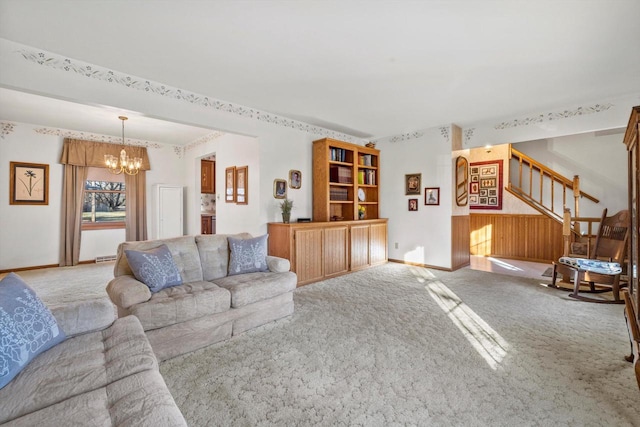 carpeted living room featuring wood walls and a notable chandelier