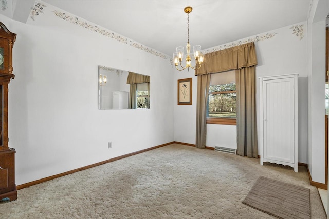 empty room with carpet and a chandelier