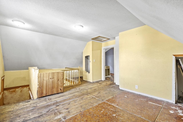 bonus room with a textured ceiling, lofted ceiling, and wood-type flooring