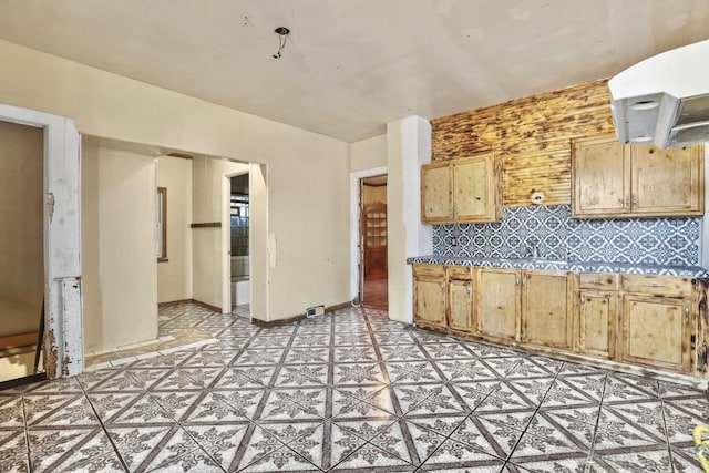 kitchen featuring light brown cabinetry and tasteful backsplash